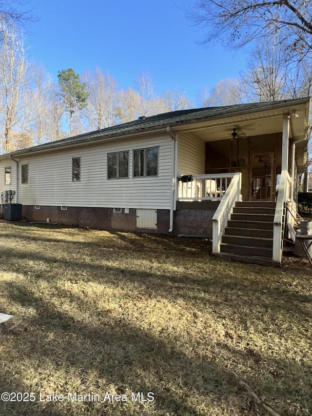 rear view of house featuring ceiling fan, a yard, and central air condition unit