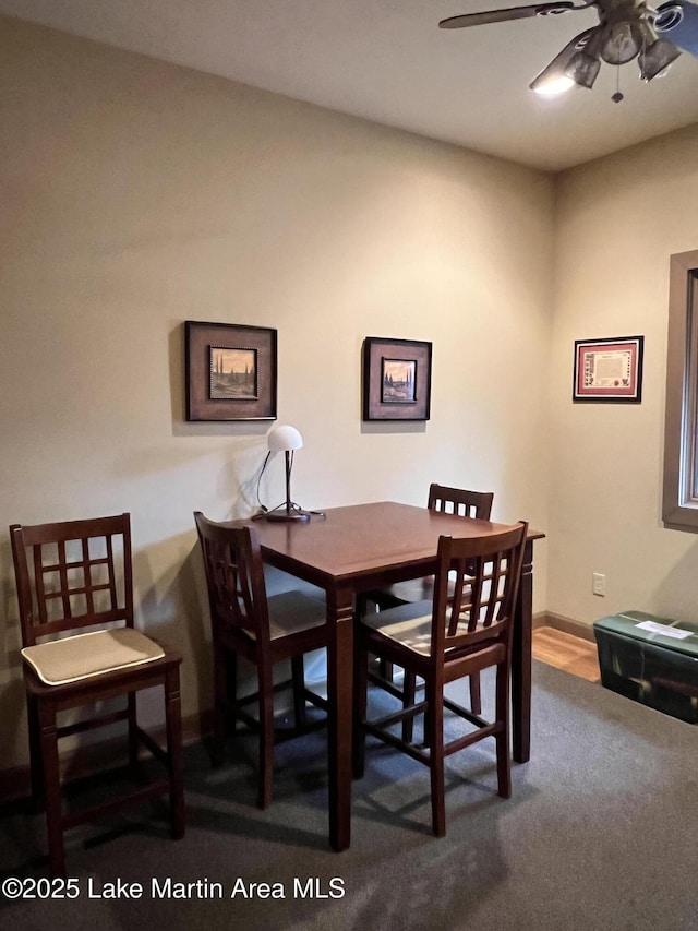 carpeted dining room featuring ceiling fan