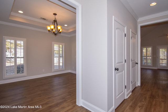 corridor featuring dark hardwood / wood-style flooring, crown molding, plenty of natural light, and a notable chandelier