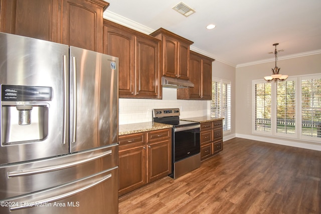 kitchen with dark hardwood / wood-style floors, ornamental molding, a notable chandelier, light stone counters, and stainless steel appliances