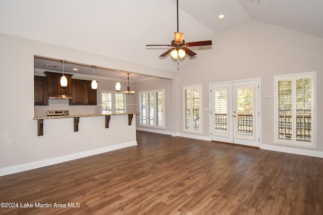 unfurnished living room featuring french doors, ceiling fan with notable chandelier, crown molding, high vaulted ceiling, and dark hardwood / wood-style floors