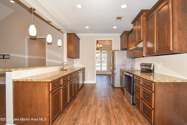 kitchen featuring sink, light hardwood / wood-style flooring, decorative light fixtures, kitchen peninsula, and stainless steel appliances