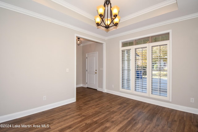 spare room featuring a chandelier, dark hardwood / wood-style floors, and ornamental molding