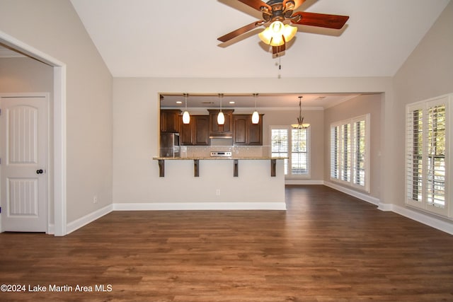 kitchen featuring a kitchen breakfast bar, hanging light fixtures, a healthy amount of sunlight, and lofted ceiling