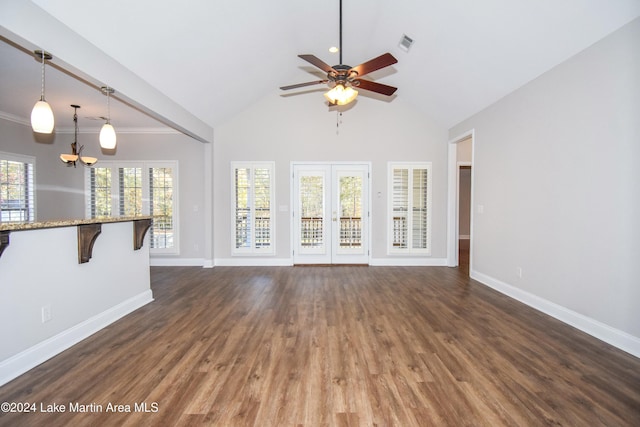 unfurnished living room featuring ceiling fan with notable chandelier, dark hardwood / wood-style flooring, high vaulted ceiling, and french doors