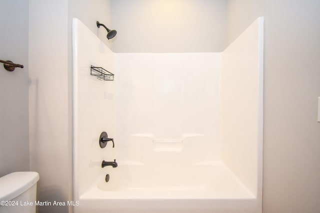 bathroom with bathing tub / shower combination and toilet