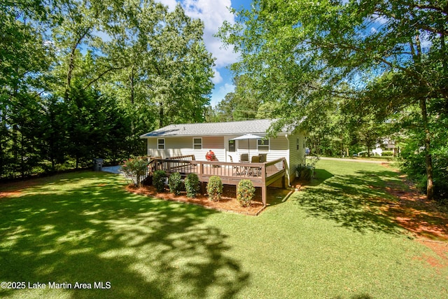 838 Bama Park Rd, Dadeville, AL 36853 - rear view of house featuring a wooden deck, a yard, roof with shingles, and view of scattered trees