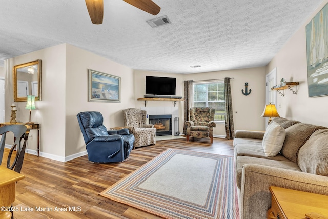 741 Lakeview Rdg, Dadeville, AL 36853 - living area featuring a fireplace, wood finished floors, a textured ceiling, and ceiling fan