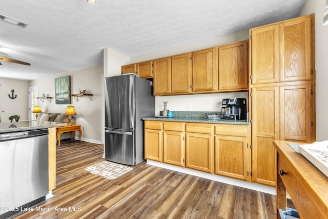 741 Lakeview Rdg, Dadeville, AL 36853 - kitchen with appliances with stainless steel finishes, wood finished floors, a textured ceiling, a ceiling fan, and open floor plan