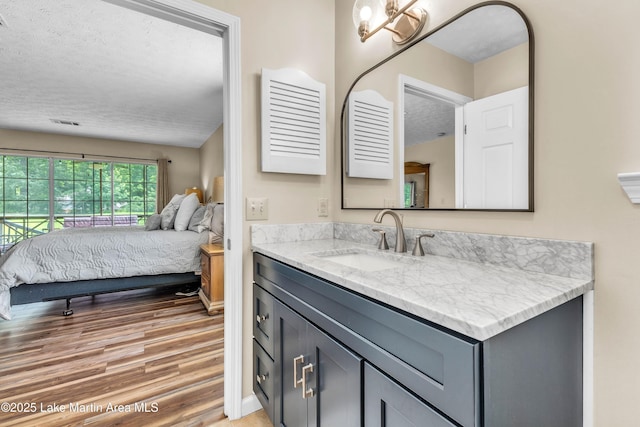 741 Lakeview Rdg, Dadeville, AL 36853 - bathroom with a textured ceiling, vanity, wood finished floors, and ensuite bathroom