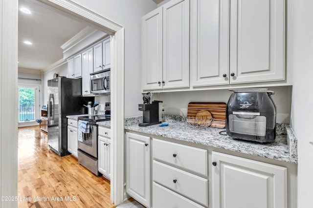 64 Stoneview Summit Ct Unit 5206, Dadeville, AL 36853 - kitchen featuring appliances with stainless steel finishes, ornamental molding, white cabinetry, light wood-style floors, and light stone counters