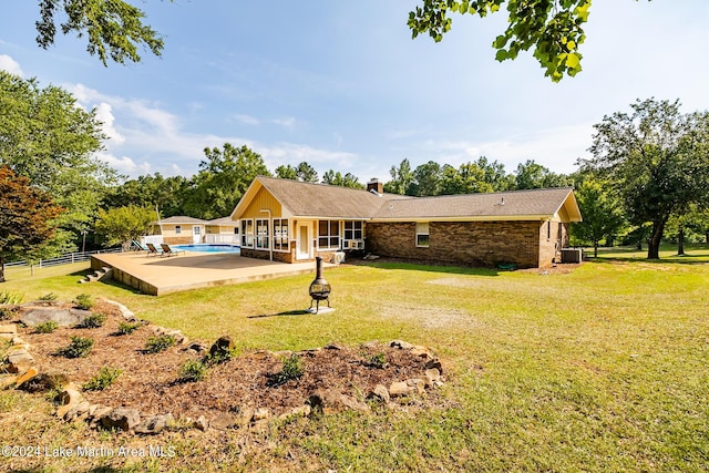 rear view of house with a yard, central AC unit, and a patio area