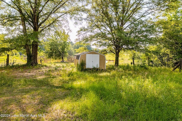 view of yard with a rural view and a storage unit