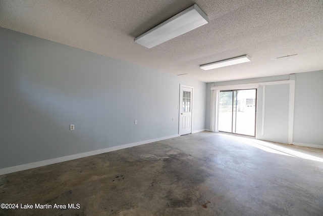 unfurnished room with concrete floors and a textured ceiling