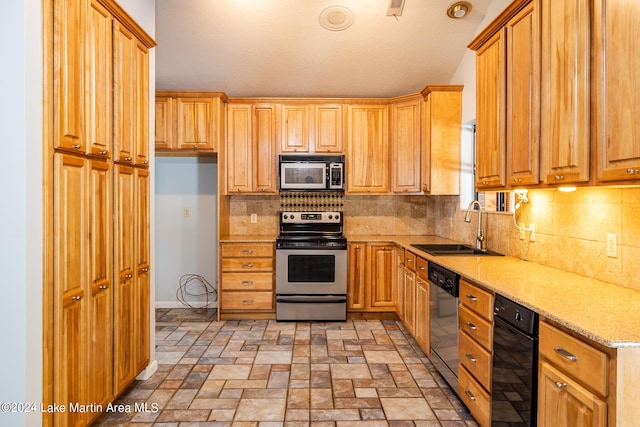 kitchen with stainless steel appliances, light stone countertops, sink, and backsplash