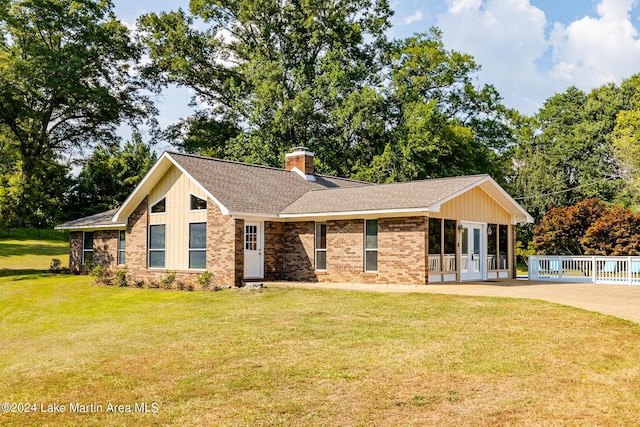 ranch-style home with a front yard and french doors