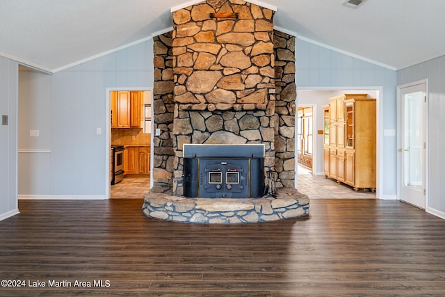 unfurnished living room featuring ornamental molding, wood-type flooring, vaulted ceiling, and a wood stove