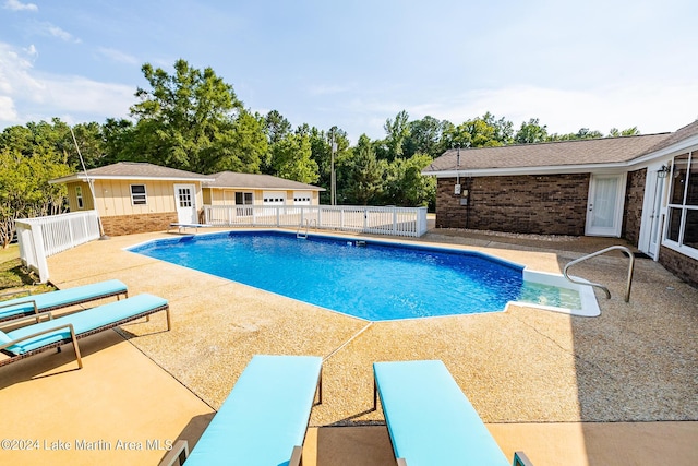 view of swimming pool with an outdoor structure and a patio