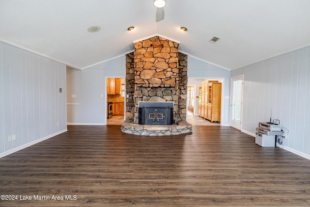 unfurnished living room with dark hardwood / wood-style floors, vaulted ceiling, and a wood stove