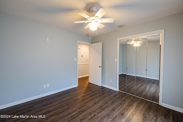 unfurnished bedroom featuring a closet, dark hardwood / wood-style floors, and ceiling fan