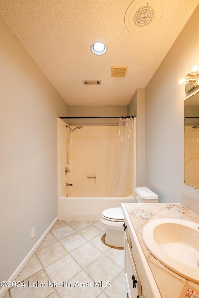 full bathroom featuring vanity, toilet, tile patterned floors, a textured ceiling, and shower / bath combo with shower curtain