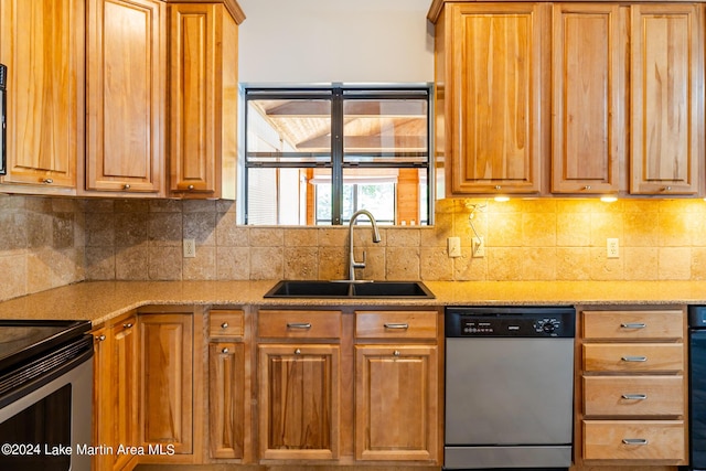 kitchen featuring light stone countertops, appliances with stainless steel finishes, sink, and decorative backsplash