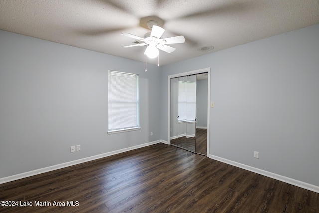 unfurnished room featuring ceiling fan, dark hardwood / wood-style flooring, a closet, and a textured ceiling