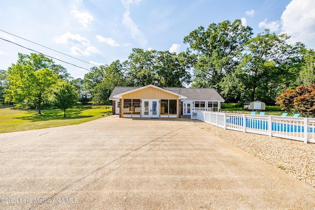 exterior space with french doors, a storage unit, and a patio area