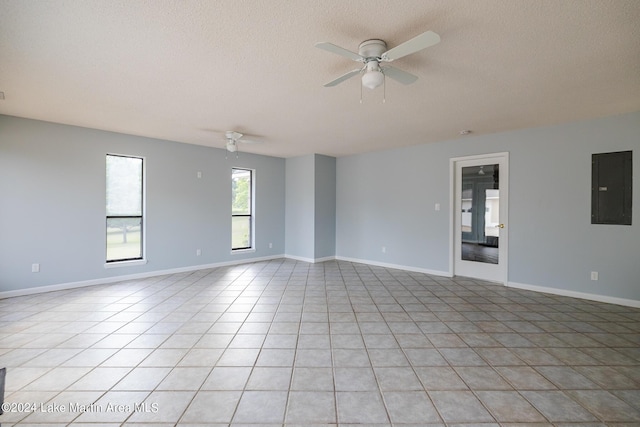 unfurnished room with ceiling fan, electric panel, a textured ceiling, and light tile patterned floors