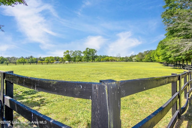 view of yard with a rural view and fence