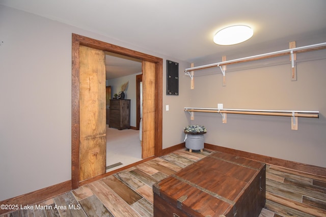 walk in closet featuring wood finished floors and electric panel