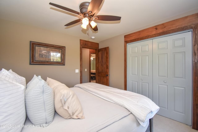 bedroom with a closet, a ceiling fan, and light carpet