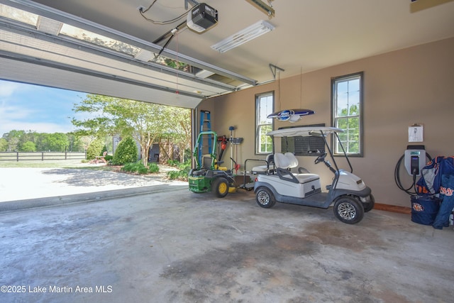 garage featuring fence and a garage door opener