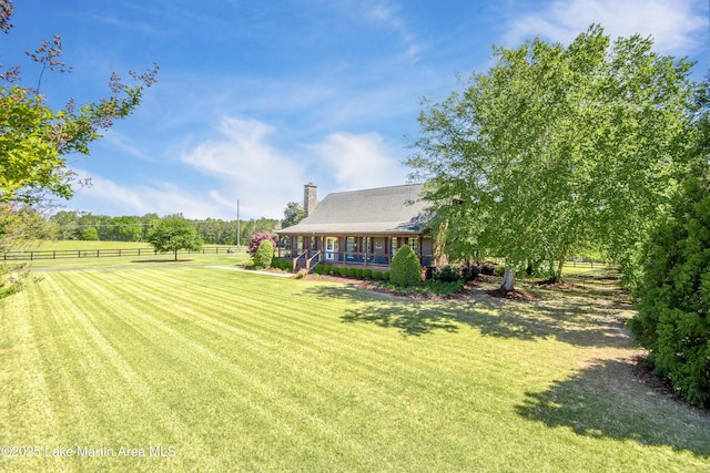 view of yard featuring fence and covered porch