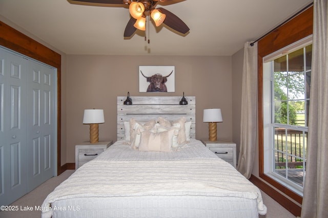 bedroom with a closet, ceiling fan, carpet, and baseboards
