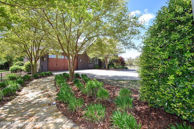 view of front facade featuring a garage, driveway, and fence