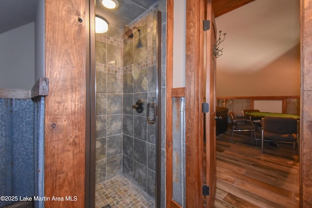 full bath featuring a stall shower and wood finished floors