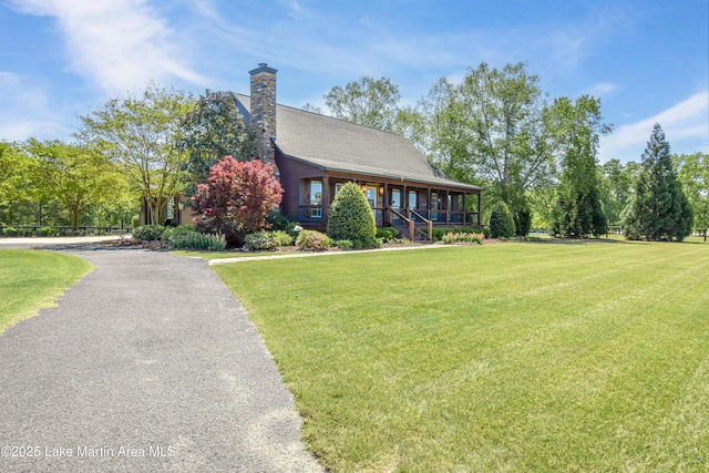 view of front of property with a front yard, a porch, and a chimney