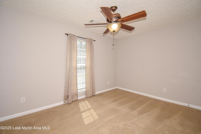 spare room featuring light carpet, ceiling fan, baseboards, and a textured ceiling