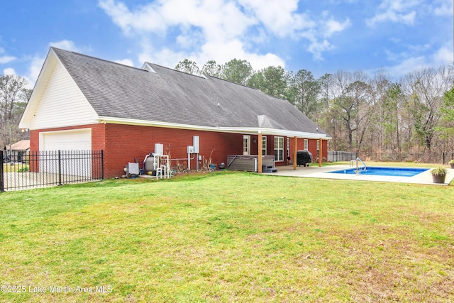 rear view of house with roof with shingles, brick siding, a lawn, a hot tub, and fence