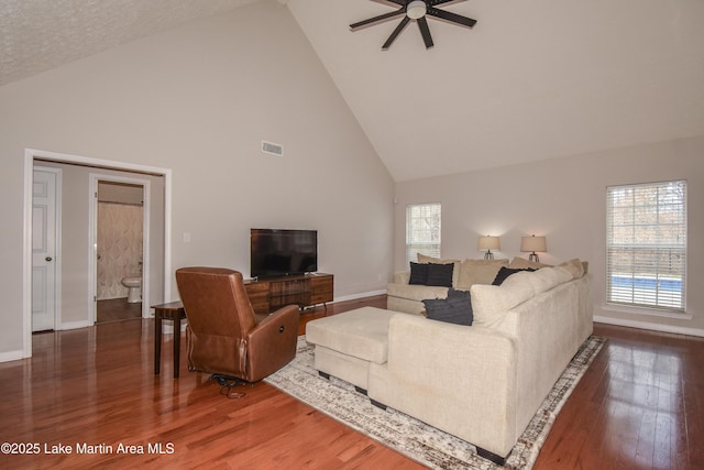 living room with visible vents, a ceiling fan, wood finished floors, high vaulted ceiling, and baseboards