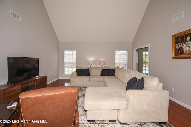 living area featuring dark wood-type flooring, a healthy amount of sunlight, and visible vents