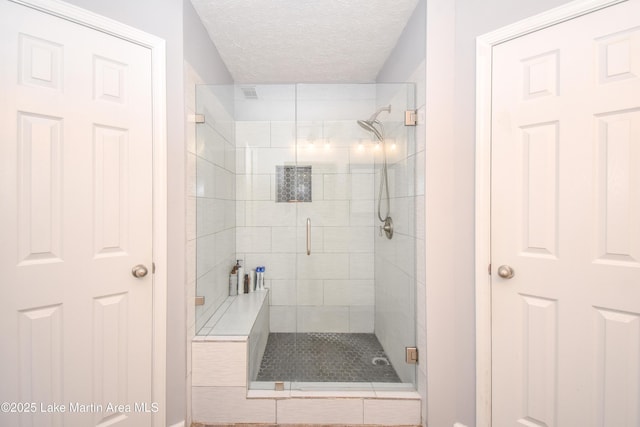 full bath featuring a stall shower and a textured ceiling