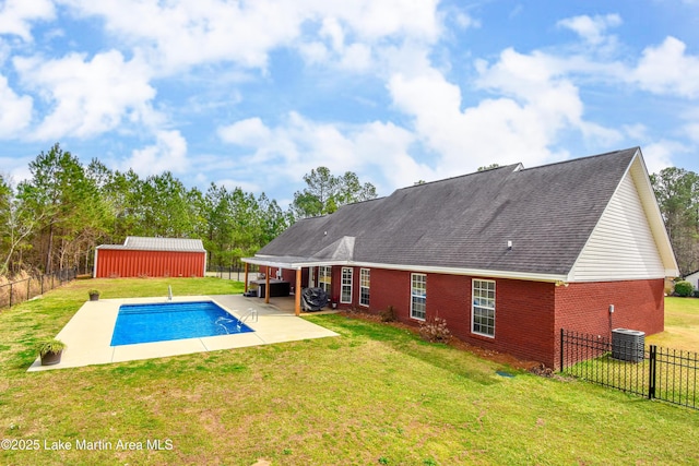 view of swimming pool with an outbuilding, a patio, a fenced backyard, a yard, and a fenced in pool