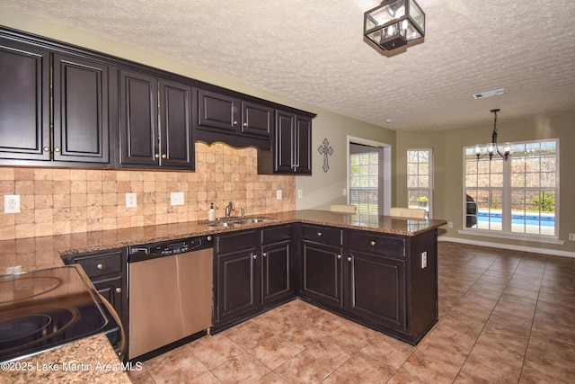 kitchen with tasteful backsplash, visible vents, dark stone counters, stainless steel dishwasher, and a sink