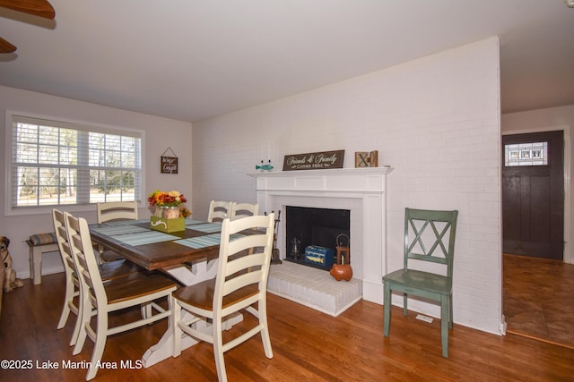 dining room featuring a fireplace and dark wood-type flooring