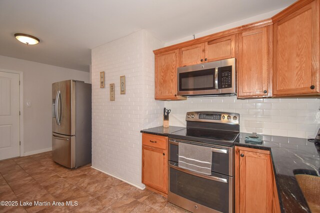 32 Dennis Creek Cir, Jacksons Gap, AL 36861 - kitchen with appliances with stainless steel finishes, decorative backsplash, brown cabinetry, and dark stone counters