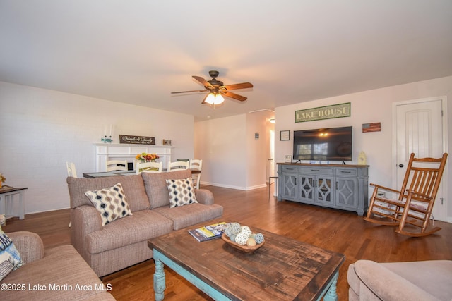living room featuring ceiling fan and dark hardwood / wood-style flooring