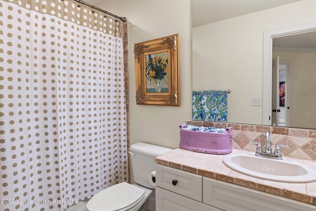 bathroom featuring curtained shower, backsplash, vanity, toilet, and crown molding