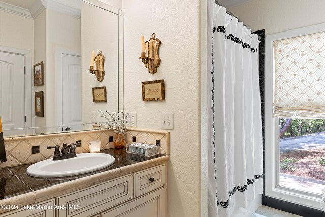 bathroom with vanity, ornamental molding, and backsplash